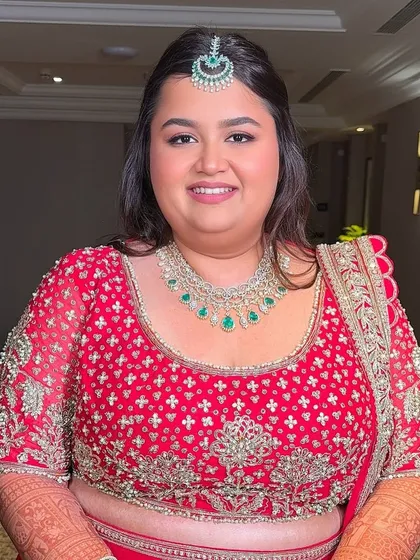 A classic bridal portrait. For this look, I focused on flawless skin, defined eyes, and a lip color that perfectly complements her traditional red attire.