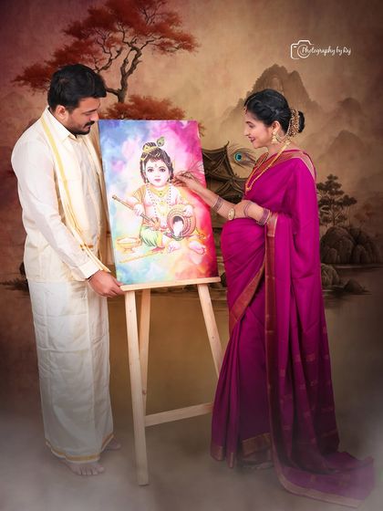A romantic studio portrait of a couple with a painting of Baby Krishna, a beautiful way to incorporate cultural elements.