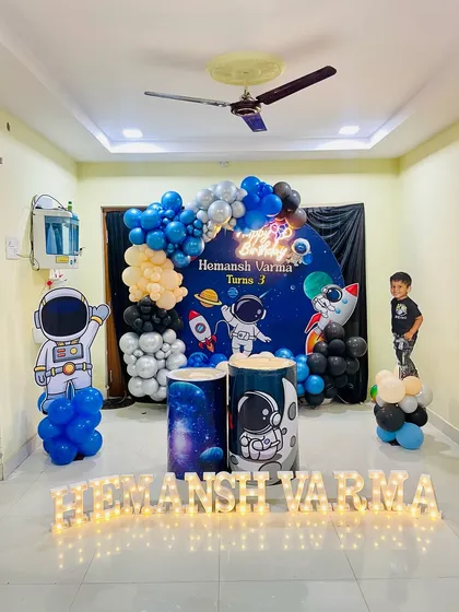 A complete Space theme decoration in a room, showing how I can create an immersive experience with a large backdrop, character props, and marquee letters.