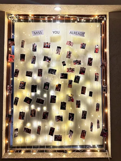 A window of memories. We created this beautiful display by hanging photos from strings of fairy lights, a perfect personal touch for a farewell party.