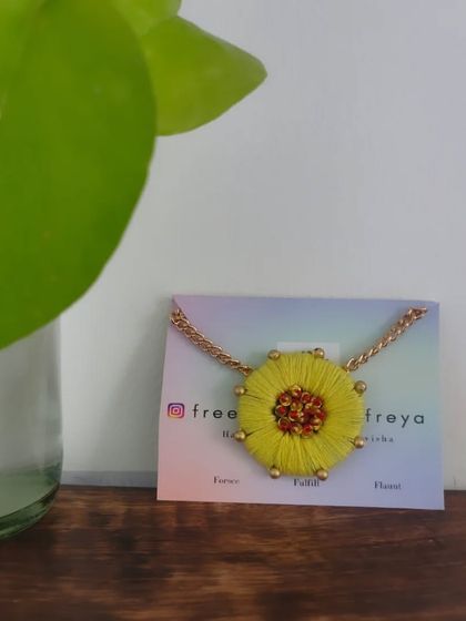 A bright and cheerful yellow flower necklace. This piece is made with thread embroidery and has a beaded center, perfect for a summery, bohemian vibe.