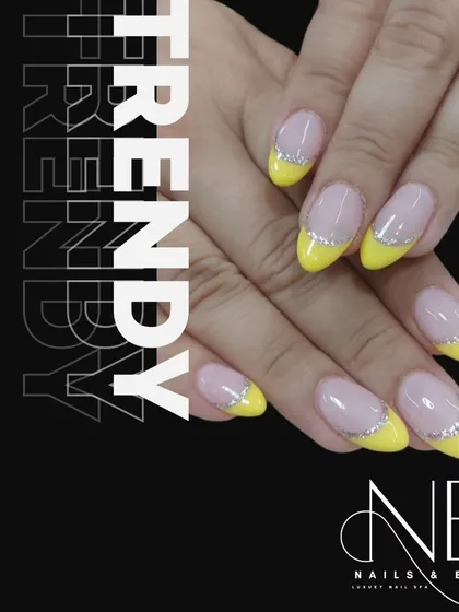 A trendy and bright French manicure with neon yellow tips and a delicate silver glitter line.