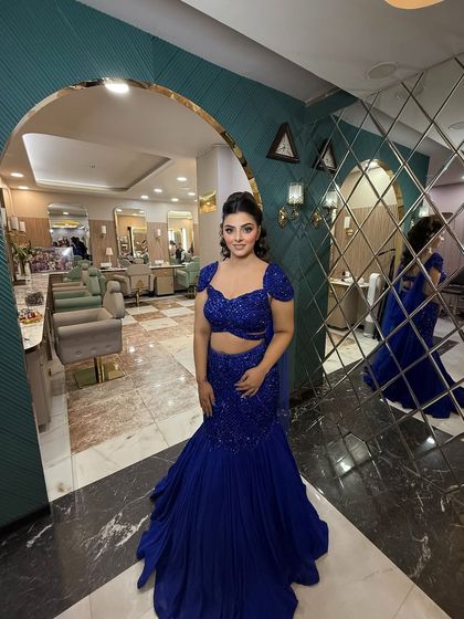 A full view of this stunning royal blue look. The mermaid-style gown and the glamorous makeup create a show-stopping silhouette.