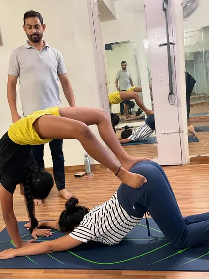Partner yoga is an important part of my classes in Rohini. This pose requires balance and trust between the two students, building teamwork and making practice enjoyable.