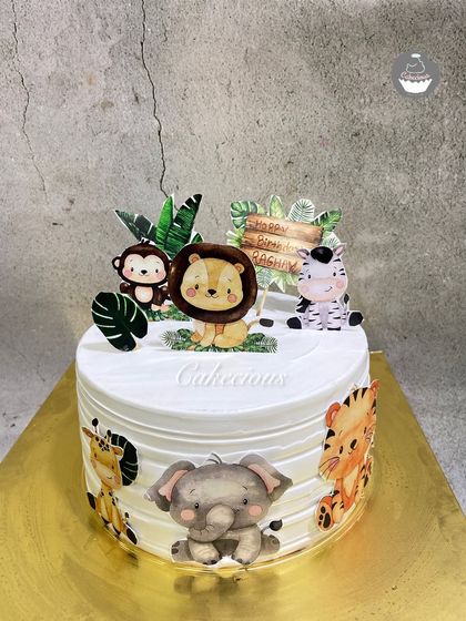 A sweet jungle adventure on a cake. This design features cute, friendly animal characters like a lion, elephant, and monkey, perfect for a safari-themed birthday party.