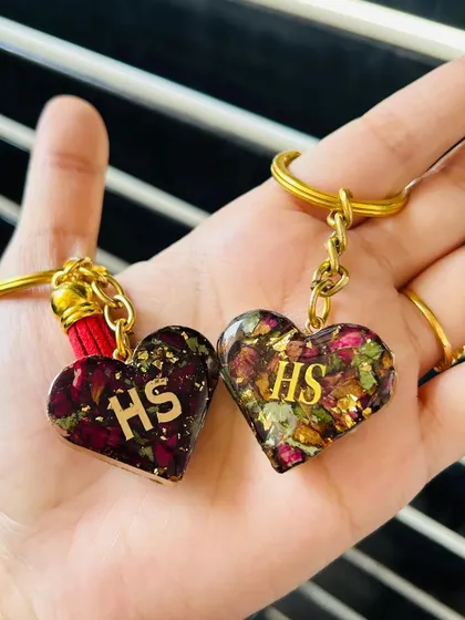 A matching set of heart-shaped resin keychains, perfect for couples or best friends. These are made with dried flowers and can be personalized with your initials.