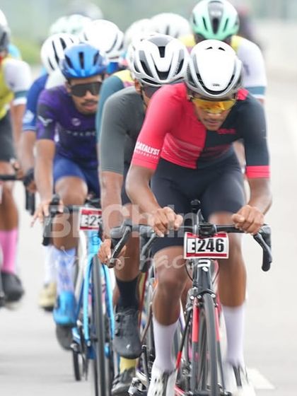 The lead group of riders stays in a tight formation, conserving energy for the final sprint. This is tactical road racing at its finest.