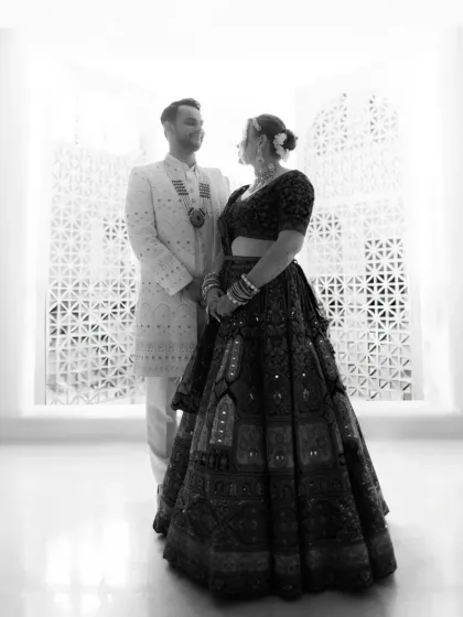 A striking black and white silhouette of the couple against a beautifully patterned wall, a modern and artistic wedding portrait.