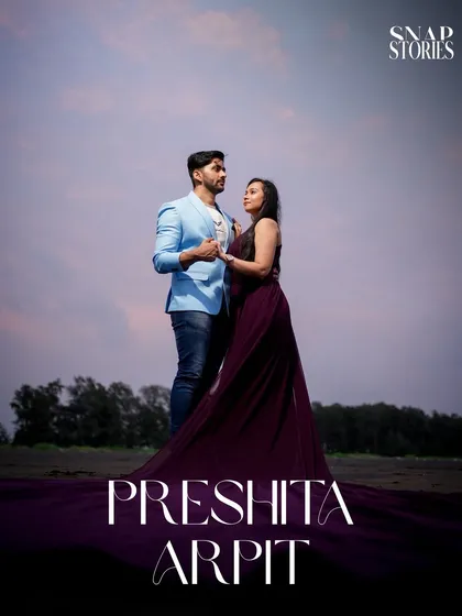 A romantic portrait of the couple standing together on the beach at dusk, creating a moody and atmospheric pre-wedding photograph.