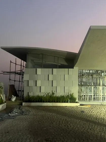 The Lonavala holiday home seen at dusk during the final stages of construction. The unique roofline and textured facade are already beginning to define the building's powerful architectural character.