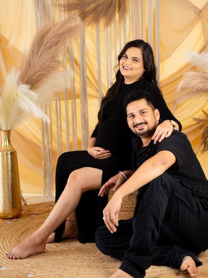 A relaxed and happy couple's portrait in our boho studio. Dressed in black, they smile warmly, creating a comfortable and intimate feel.