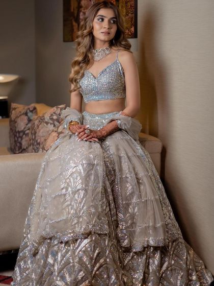 A poised and elegant portrait. The cool-toned makeup with a silver shimmer perfectly matches the icy blue and silver of her lehenga.