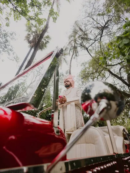 The groom, looking regal and ready for his grand entrance. We captured this low-angle shot with his vintage car to create a powerful and stylish portrait.