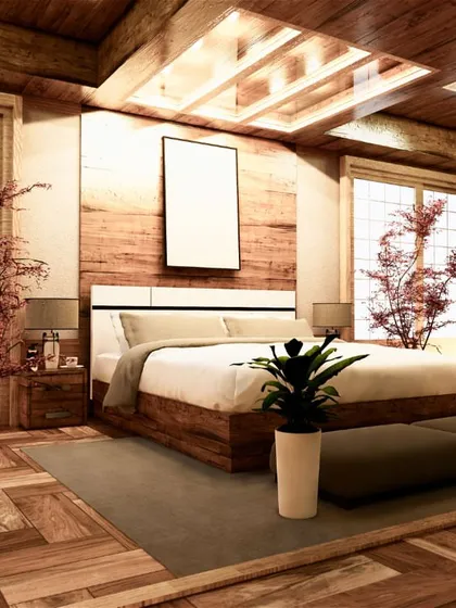 A Japanese-inspired bedroom design with extensive use of natural wood on the floors, walls, and ceiling. The low-profile bed and large windows create a calm and tranquil atmosphere.