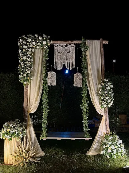 For a relaxed and romantic vibe, we created this beautiful bohemian-inspired swing. Draped in soft fabric and adorned with fresh white flowers, macrame details, and warm lighting, it made for the perfect photo spot.