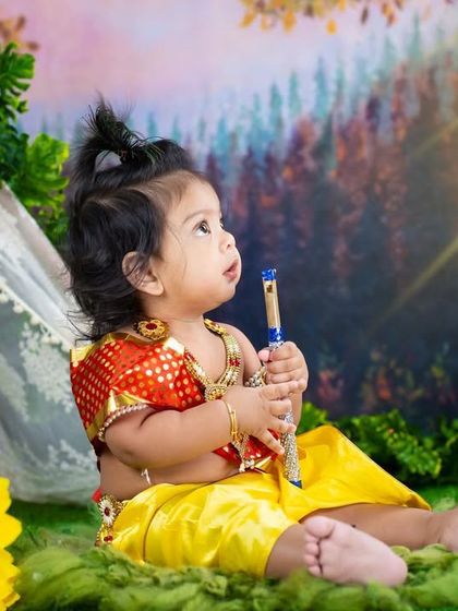 A thoughtful moment for our little Krishna, looking towards the light in a serene forest setting.