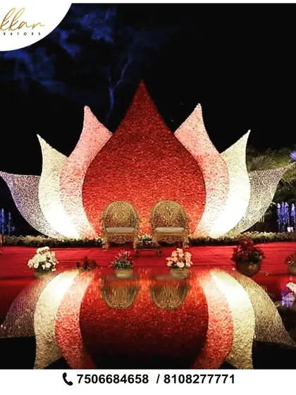 A magnificent reception stage designed with a larger than life lotus installation. The seating is framed by petals made of intricate floral work, creating a divine and royal focal point for the couple.