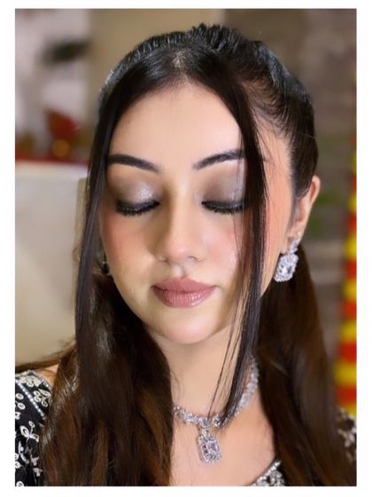 A close-up of a neutral glam look. The soft brown eyeshadow and nude lip create a sophisticated and timeless party style.