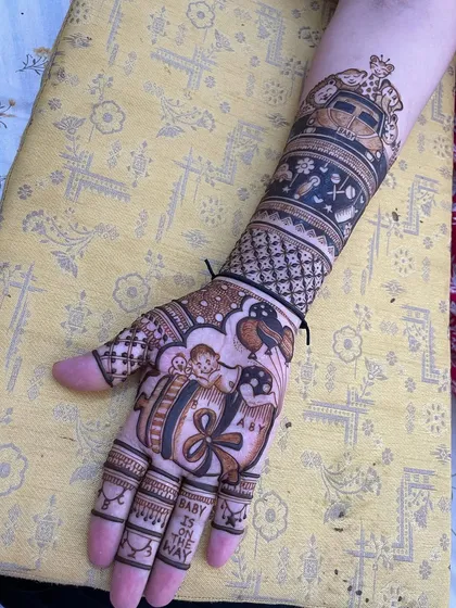A full-arm design for a baby shower. The palm features a baby in a gift box with the words "Baby is on the way," a truly adorable and personal touch.