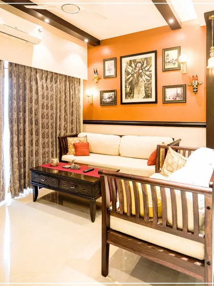 A living room with a Durga-inspired gallery wall against a terracotta-colored accent wall, channeling devotional energy.