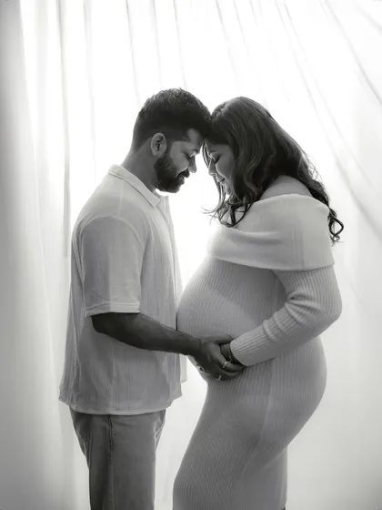 A simple, tender moment. This black and white portrait captures the quiet connection between the couple, with soft backlighting creating an intimate and gentle mood.