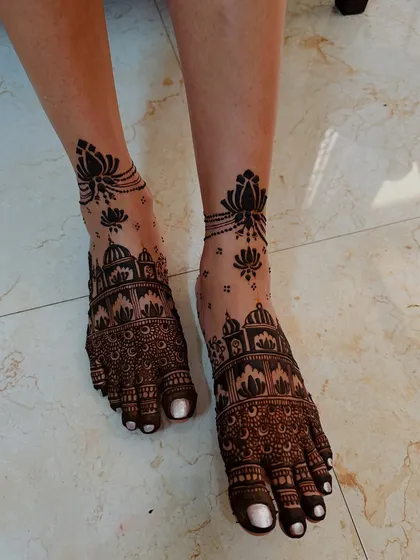Architectural domes and lotus motifs adorn these feet, creating a unique and artistic statement. The anklet of floating lotuses adds a modern touch.
