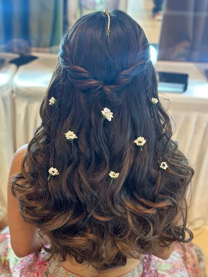 Elegance in every petal and every curl. This half-up style features a simple twist and is adorned with small, delicate white flowers.