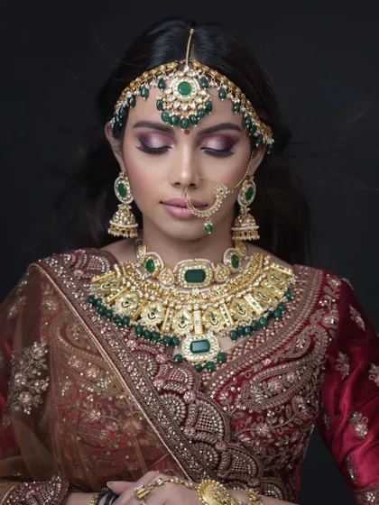 Eyes closed to show the purple and gold eyeshadow work.