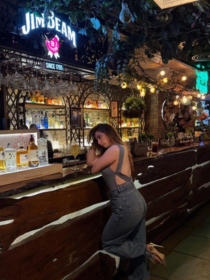 A candid-style shot at the bar in a grey top and denim. This look is perfect for a relaxed evening out and shows a more casual side of my party wear styling.