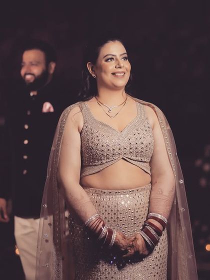 A beautiful candid moment from a reception. The bride is in focus, glowing with happiness, while the groom smiles lovingly in the background. It’s a shot full of warmth and affection.