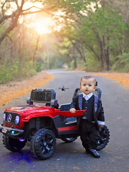 Posing like a pro. This little gentleman shows off his style next to his red toy jeep during his first birthday outdoor photoshoot.