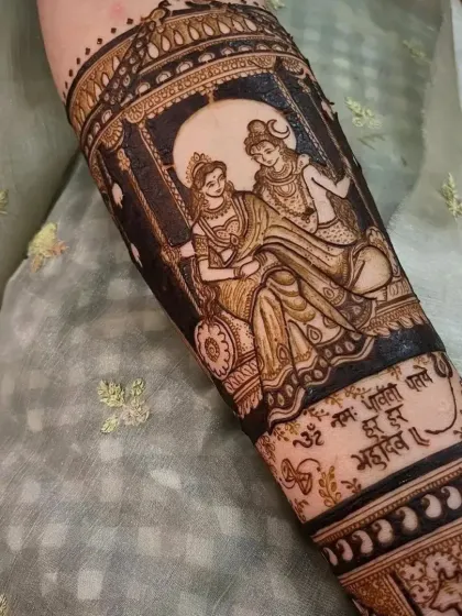 For brides who want a spiritual touch, I create divine portraits like this one of Shiva and Parvati on a swing. This image shows the design after the henna paste has been applied, with a sacred mantra written below to add a special blessing to the bridal art.