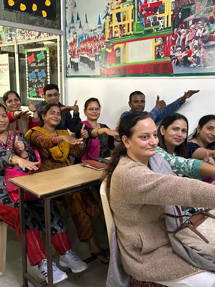 A classroom of smiling parents during our orientation program. We aim to improve parent-child interactions by helping parents anticipate developmental changes and provide early learning experiences.