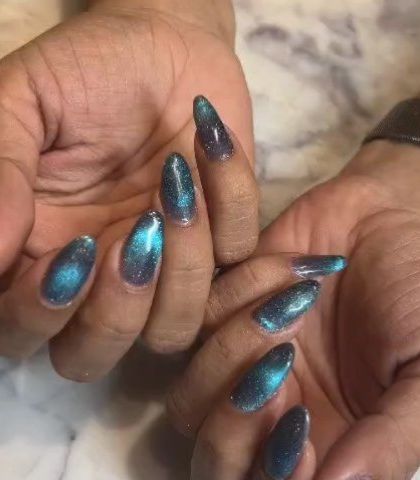A close-up of the teal cat-eye nails, showing the bright line of shimmer that gives this polish its signature look.
