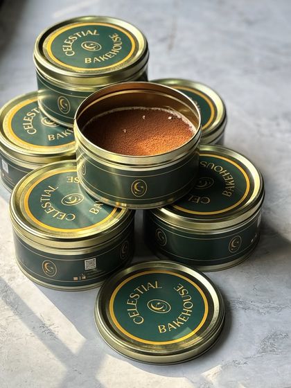 Our Classic Tiramisu, ready to go in our signature Cosmic Tins. We stack them high, preparing for a busy day of deliveries.