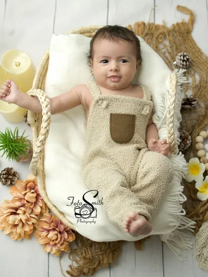 A little wave from this charming baby. His expressive face and gesture make this a lively and engaging portrait.