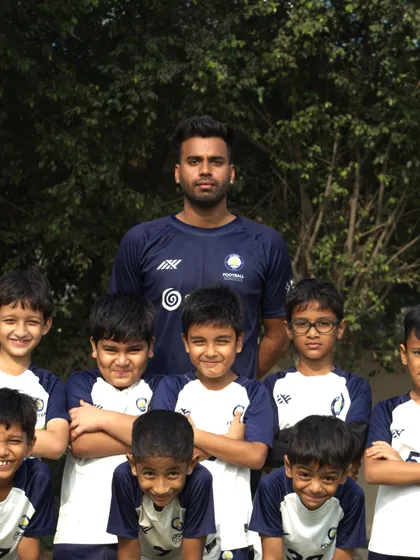 A team photo with their coach, showing the unity and spirit of the School Soccer League.