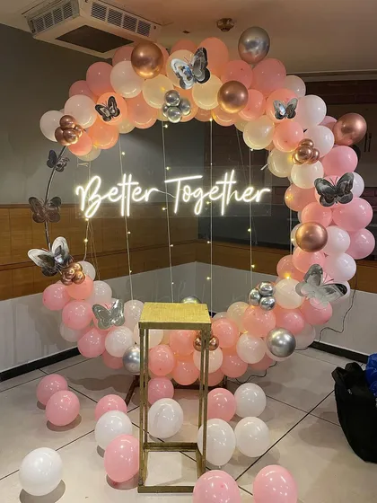 This "Better Together" neon sign is a popular choice for anniversaries and engagement parties. I framed it with a custom circular balloon arch using soft pink, white, and chrome balloons, adding butterfly details for a whimsical touch.