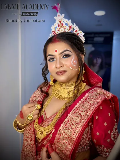 A classic portrait of a Bengali bride. The makeup is flawless, with a focus on creating a radiant complexion and defining the eyes, ensuring the bride looks her absolute best.