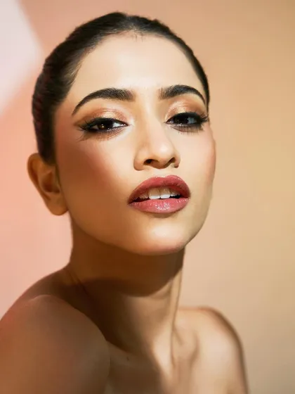 A confident and striking portrait. The glossy, bold lip and sharp liner combo is perfect for someone who isn't afraid to stand out.