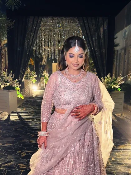 The full look against the beautiful evening decor. The glamorous makeup and elegant outfit make her the center of attention.