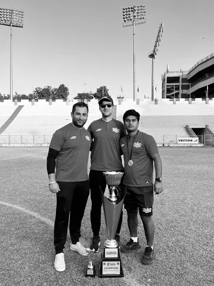 The masterminds. Our coaching and management staff with the trophy, the architects behind the team's success.