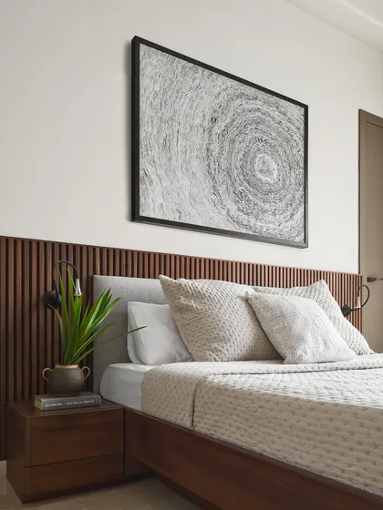 The Taupe Bedroom in Lumen House is a sanctuary of calm. A fluted wood headboard adds texture and warmth, complemented by meditative art and a natural color palette to create an urban oasis for relaxation and rest.