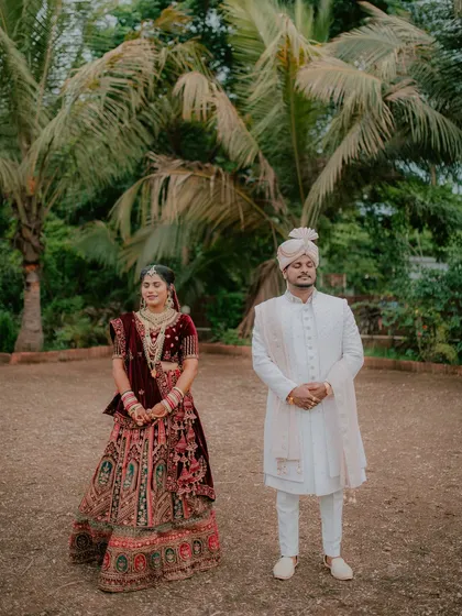 A formal portrait of the couple in their reception attire, captured outdoors with natural lighting.