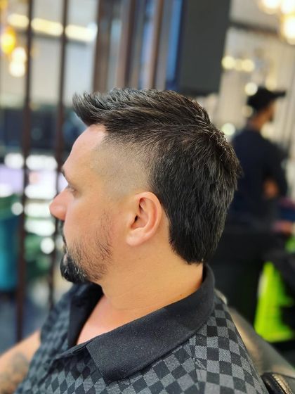 A side view of a modern mullet. This style is all about texture and flow, with shorter sides and a longer back.