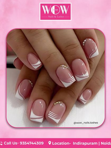 A modern, graphic take on the French manicure. This design features sharp white lines and delicate rhinestone accents on a glossy, natural-looking base.