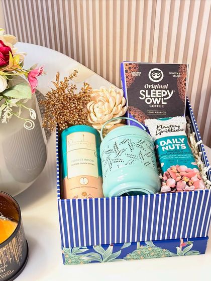The Royal Indulgence hamper is a treat for the senses. This festive blue box contains Sleepy Owl coffee, a decorative lantern, a premium nut mix, and fragrant incense cones, creating a perfect moment of relaxation during the busy festival season.