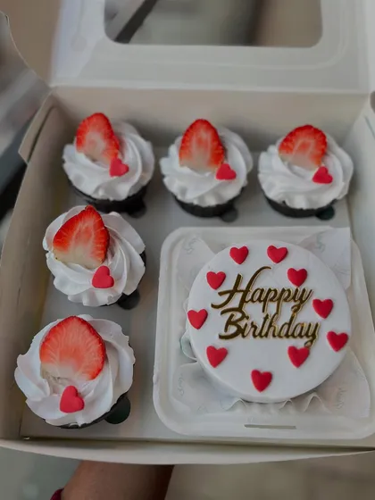 My bento cake and cupcake combos are perfect for intimate celebrations. This set includes a "Happy Birthday" mini cake decorated with hearts, paired with six chocolate cupcakes topped with fresh cream and strawberries.