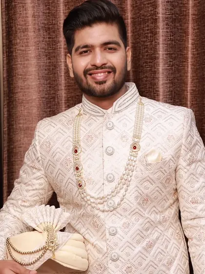 A close-up of the groom holding his turban. This highlights the flawless skin finish and the subtle definition that makes the groom look fresh and ready for his big day.