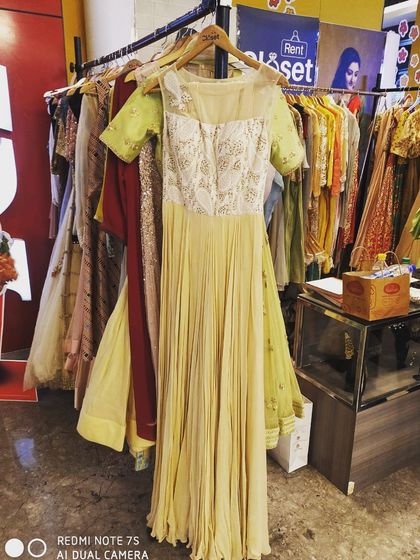 This pale yellow gown with an embroidered bodice and pleated skirt is seen here on a hanger in our store. This image gives you a real sense of the beautiful pieces you can find while browsing our collection.